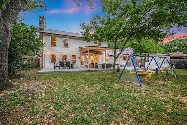 11903 Brookwood Cir, Austin, TX 78750 - back of property with a playground, a chimney, a wooden deck, a metal roof, and a standing seam roof