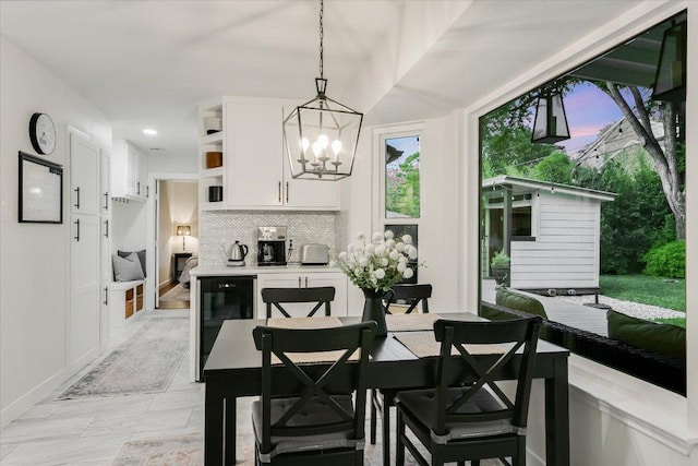 dining space featuring baseboards, an inviting chandelier, recessed lighting, and beverage cooler