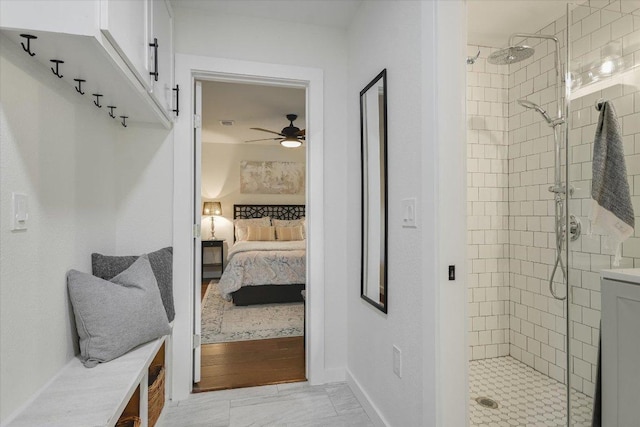 bathroom featuring a stall shower, ensuite bathroom, a ceiling fan, and baseboards