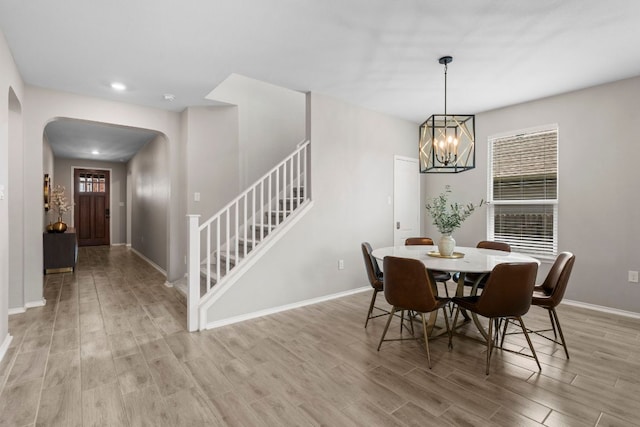 330 Conestoga Dr, Kyle, TX 78640 - dining space with arched walkways, stairs, light wood finished floors, a chandelier, and recessed lighting