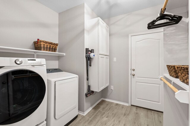 330 Conestoga Dr, Kyle, TX 78640 - washroom featuring cabinet space, light wood-type flooring, and separate washer and dryer