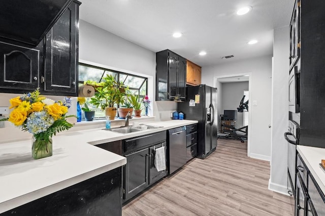 508 Explorer, Lakeway, TX 78734 - kitchen with appliances with stainless steel finishes, dark cabinetry, recessed lighting, light countertops, and light wood-style floors
