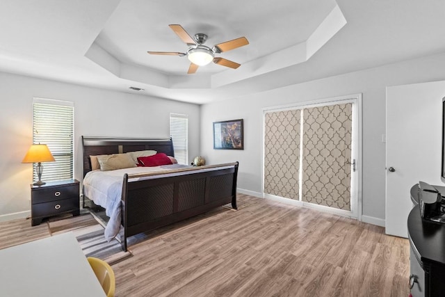 508 Explorer, Lakeway, TX 78734 - bedroom featuring a raised ceiling, wood finished floors, and a ceiling fan