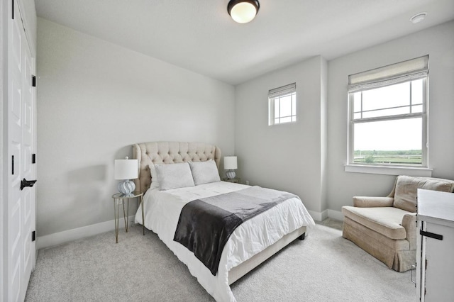 bedroom featuring light carpet and baseboards