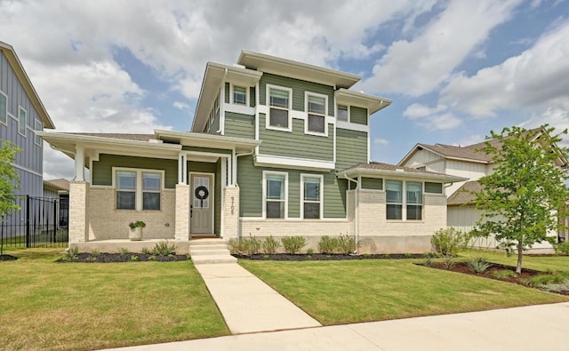 view of front of property with a front lawn, fence, covered porch, and brick siding