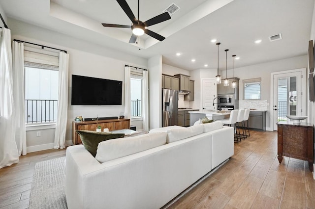 living area with visible vents, ceiling fan, recessed lighting, and light wood-style floors
