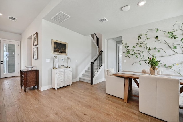 entrance foyer featuring visible vents, light wood finished floors, and stairs