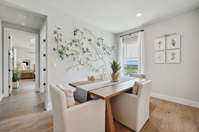 dining area featuring light wood finished floors, recessed lighting, and baseboards