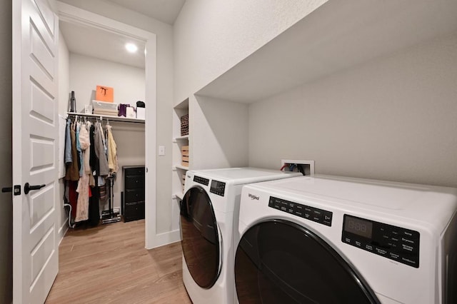 washroom featuring light wood finished floors, washer and dryer, laundry area, and baseboards