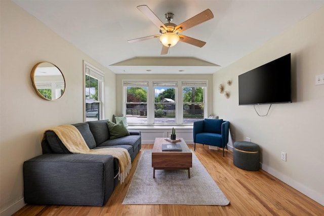 living area with a ceiling fan, baseboards, wood finished floors, and a healthy amount of sunlight