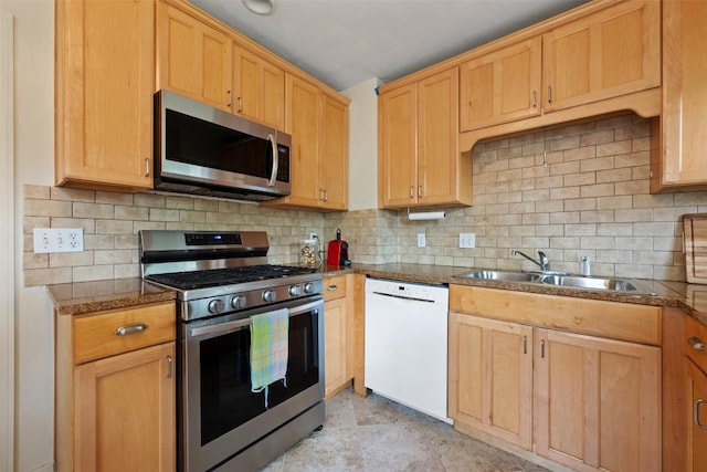 kitchen featuring appliances with stainless steel finishes, tasteful backsplash, and a sink