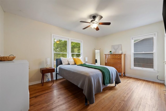 bedroom featuring baseboards, a ceiling fan, and light wood-style floors