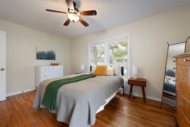 bedroom with hardwood / wood-style floors, baseboards, and a ceiling fan