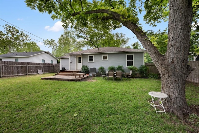 rear view of property with a deck, a fenced backyard, and a yard