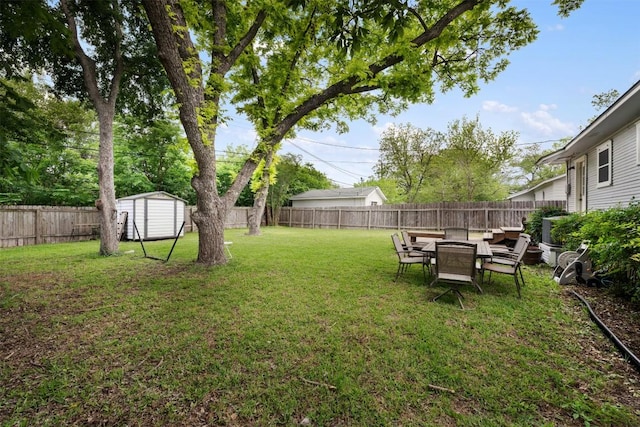 view of yard featuring a storage unit, an outdoor structure, and a fenced backyard