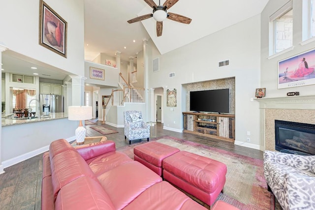 8236 Phantom Canyon Dr, Austin, TX 78726 - living room featuring high vaulted ceiling, ceiling fan, stairway, a glass covered fireplace, and wood finished floors