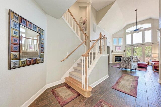 8236 Phantom Canyon Dr, Austin, TX 78726 - stairway with a ceiling fan, a tile fireplace, wood finished floors, and high vaulted ceiling