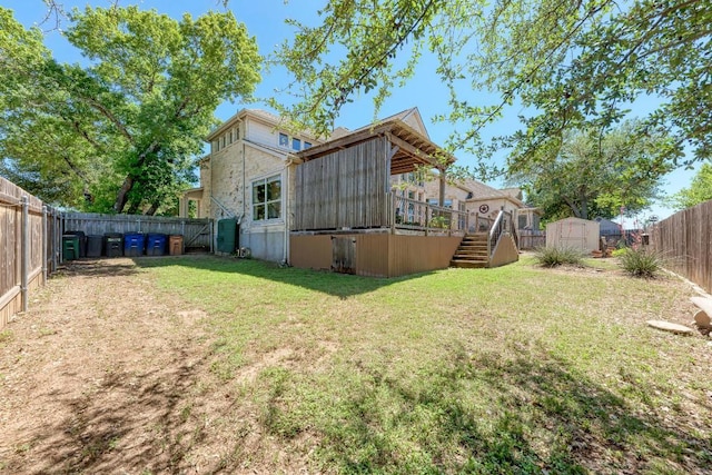 view of yard featuring a fenced backyard, an outbuilding, a wooden deck, a shed, and stairs