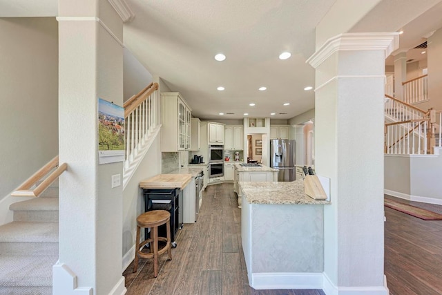 kitchen featuring baseboards, recessed lighting, stainless steel appliances, and wood finished floors
