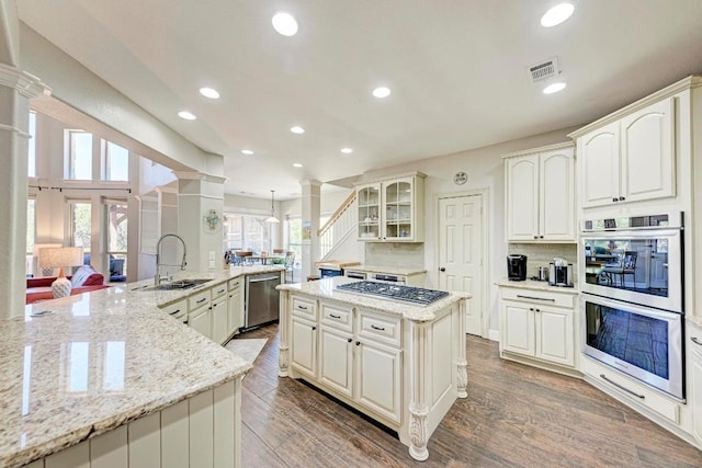 8236 Phantom Canyon Dr, Austin, TX 78726 - kitchen with stainless steel appliances, a sink, ornate columns, a large island, and recessed lighting