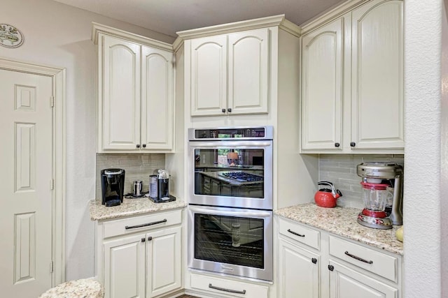 8236 Phantom Canyon Dr, Austin, TX 78726 - kitchen featuring stainless steel double oven, decorative backsplash, and light stone countertops