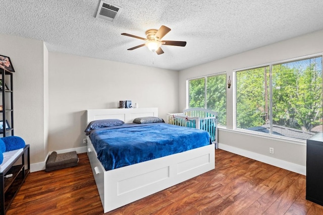 16918 Ardisia Dr, Pflugerville, TX 78660 - bedroom featuring wood finished floors, a textured ceiling, ceiling fan, and baseboards