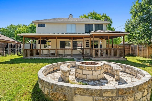 rear view of property with a fire pit, ceiling fan, and a fenced backyard