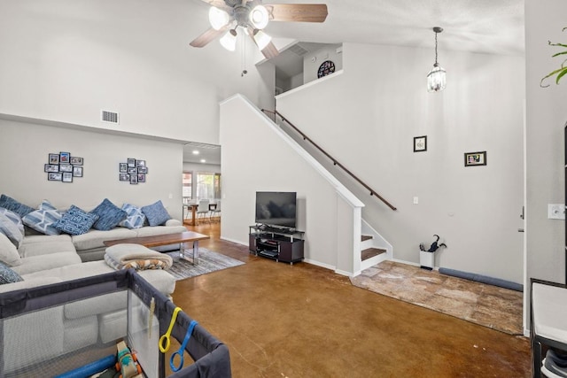 living room featuring a towering ceiling, stairway, visible vents, and a ceiling fan