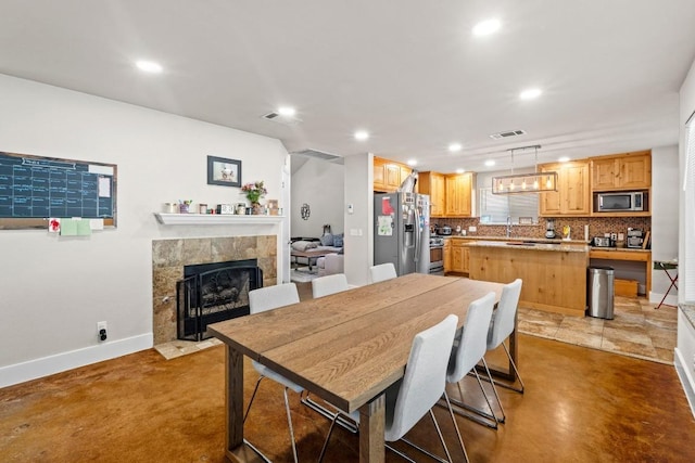 dining area featuring recessed lighting, a tile fireplace, visible vents, and baseboards