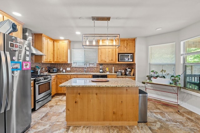 kitchen featuring backsplash, appliances with stainless steel finishes, a kitchen island, and a sink