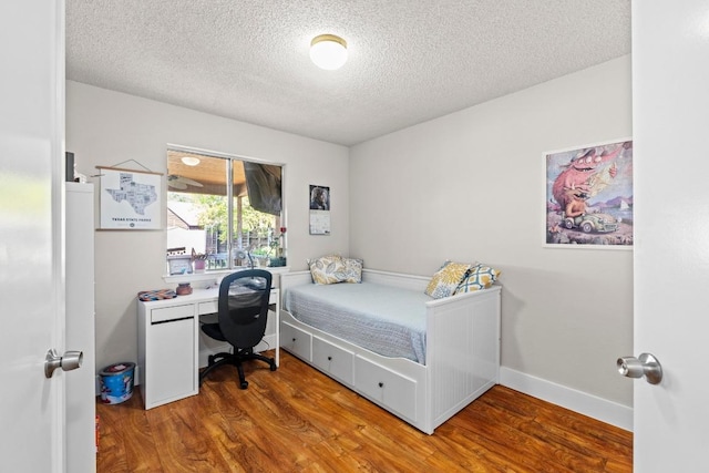 bedroom featuring wood finished floors and a textured ceiling