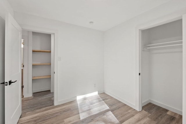 502 Oakley Ct, Austin, TX 78753 - unfurnished bedroom featuring wood finished floors, a closet, baseboards, and a spacious closet