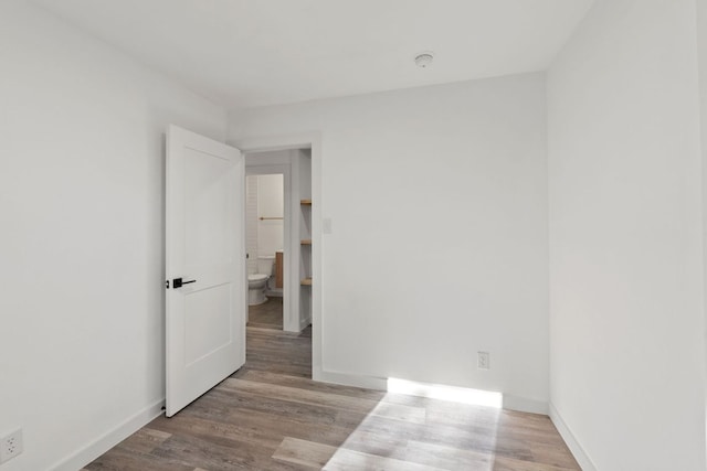 unfurnished room with wood finished floors and baseboards