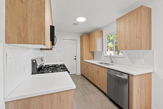kitchen featuring a sink, visible vents, backsplash, light countertops, and appliances with stainless steel finishes