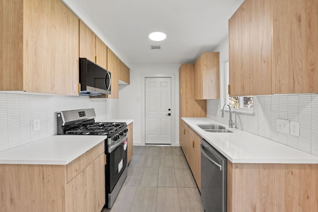 kitchen featuring decorative backsplash, a sink, appliances with stainless steel finishes, visible vents, and light brown cabinetry
