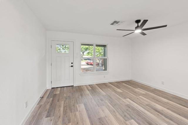 interior space with light wood finished floors, ceiling fan, baseboards, and visible vents
