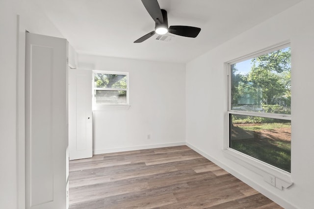 spare room with wood finished floors, ceiling fan, and baseboards