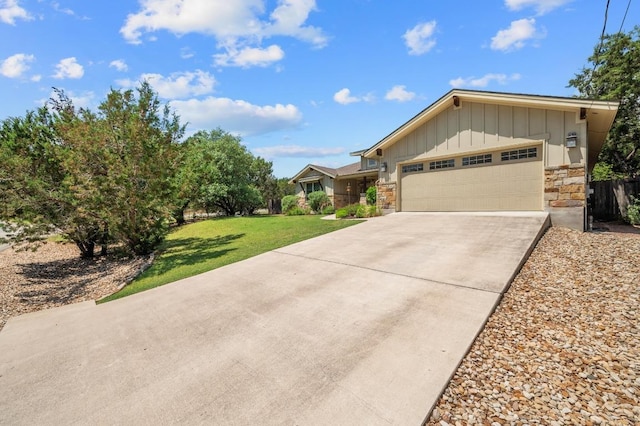 view of front facade with a front yard, a garage, stone siding, board and batten siding, and concrete driveway