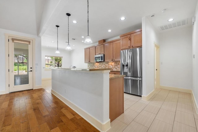 kitchen with visible vents, appliances with stainless steel finishes, decorative backsplash, and baseboards