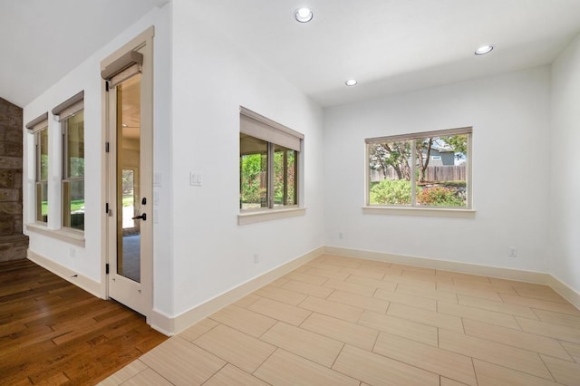 spare room featuring baseboards, recessed lighting, and light wood-style floors