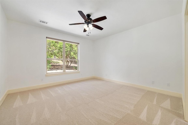 unfurnished room with light colored carpet, visible vents, a ceiling fan, and baseboards