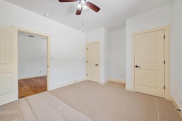 unfurnished bedroom with visible vents, ceiling fan, carpet, and baseboards