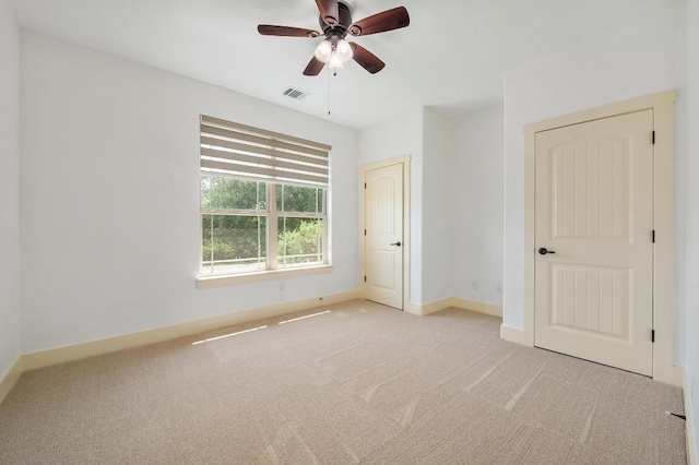 unfurnished bedroom with baseboards, visible vents, a ceiling fan, and carpet