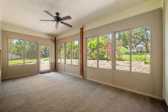 unfurnished sunroom with carpet, a healthy amount of sunlight, and baseboards