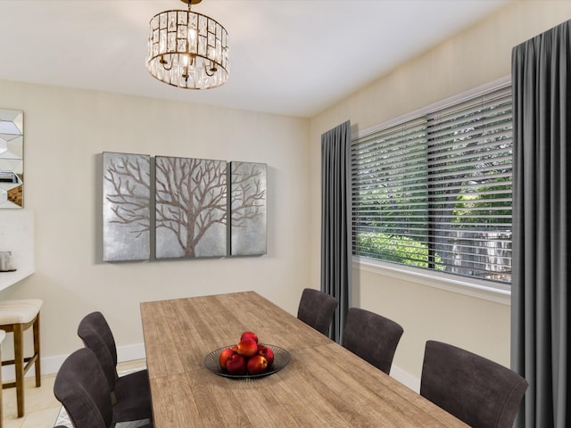 dining space with an inviting chandelier and baseboards