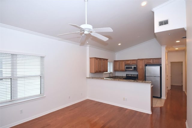 3007 Speedway Unit 6, Austin, TX 78705 - kitchen featuring brown cabinets, appliances with stainless steel finishes, visible vents, light wood-type flooring, and a peninsula