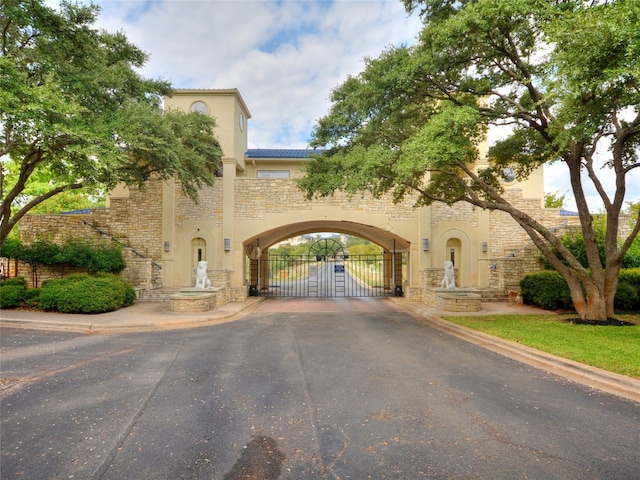 exterior space with curbs, a gated entry, and a gate