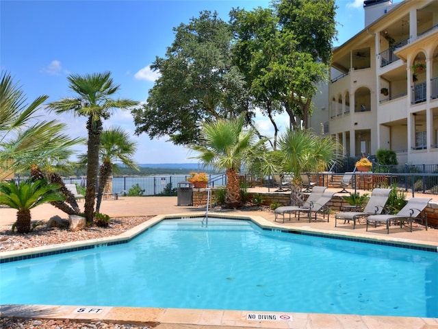 community pool featuring a patio area and fence