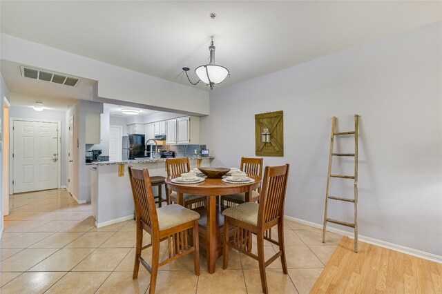 dining space with light tile patterned flooring, visible vents, and baseboards
