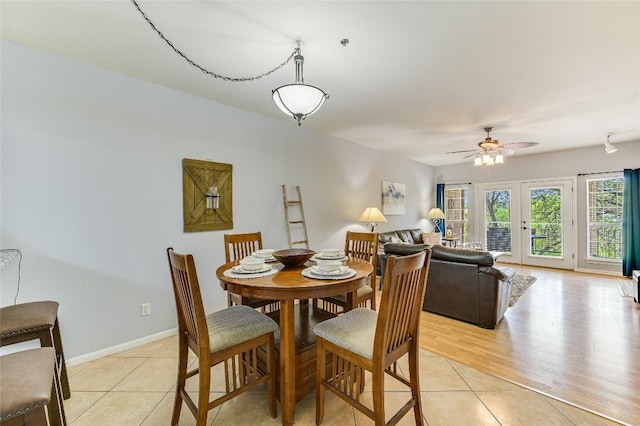 dining area featuring light tile patterned floors, a ceiling fan, and baseboards